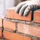 Close Up Of Industrial Bricklayer Installing Bricks On Construct